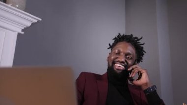 Genç ve başarılı Afrikalı Amerikalı iş adamı telefonda konuşuyor.