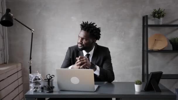 Bello uomo d'affari afroamericano in abito classico utilizza laptop e sorrisi mentre lavora in ufficio — Video Stock