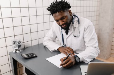 Laptop üzerinde çalışan yakışıklı Afro-Amerikan doktor. teletıp
