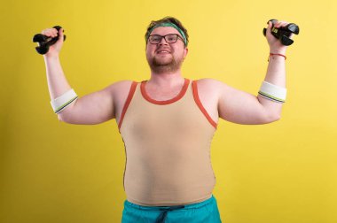 Komik şişman adam spora gider. Dambıl pazısı egzersizi yapar mı?