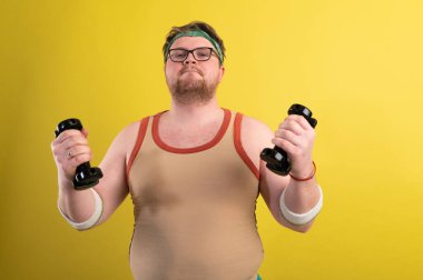 Komik şişman adam spora gider. Dambıl pazısı egzersizi yapar mı?