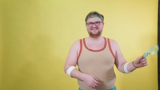 Grappige dikke man in sportkleding neemt metingen van het lichaamsvolume — Stockvideo