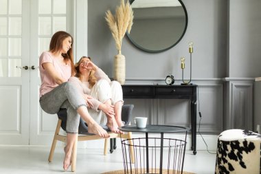 İki güzel kız arkadaş evde birlikte vakit geçiriyorlar.