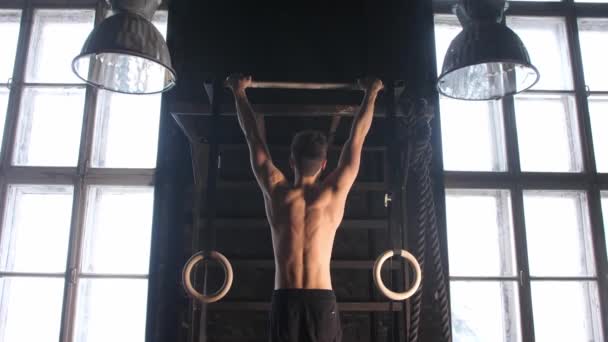 Spor salonundaki adam kaslarını şişiriyor spor salonundaki çıplak bedeninde barfiks egzersizleri yapıyor. Sırt kaslarını çalıştıran yakışıklı, güçlü atletik adamlar. — Stok video