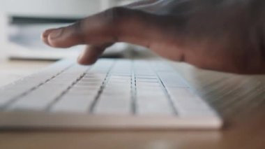 Siyah adam bilgisayarda çalışıyor. Klavyede metin yazılıyor