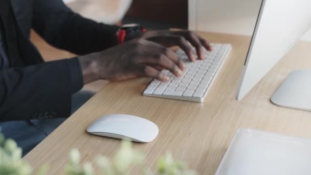 Ο μαύρος δουλεύει σε υπολογιστή. Πληκτρολόγηση κειμένου στο πληκτρολόγιο — Αρχείο Βίντεο
