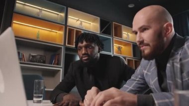 Modern bir ofiste iş görüşmesi. Arkadaş canlısı yaratıcı çeşitli çalışma arkadaşları online proje hakkında tartıştılar. İş yerinde bilgisayar kullandılar, çok ırklı çalışma grupları oluşturdular.