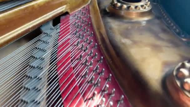 Klasik eski bir piyanonun kapağının altında hareket eden kamera piyano tellerini gösteriyor ve piyano tuşlarının önünde duruyor.. — Stok video