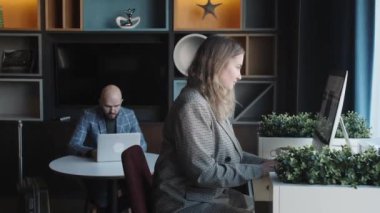 İş kadını çalışma masasındaki ofiste kahve içer.