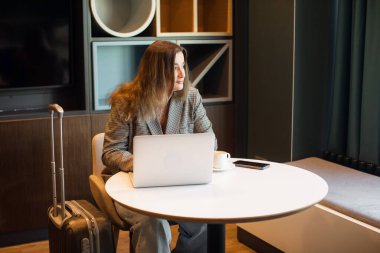 Genç bayan metin yazarı içerik web sitesine yazılar yüklemek için kapalı alanda çalışırken ağ kitabı kullanıyor