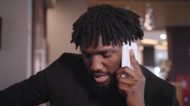 Afrikansk amerikansk affärsman i kostym pratar i telefon — Stockvideo