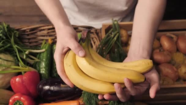 Legumes orgânicos. Mãos de agricultores com bananas recém-colhidas. Bananas orgânicas frescas. Mercado das frutas e produtos hortícolas — Vídeo de Stock