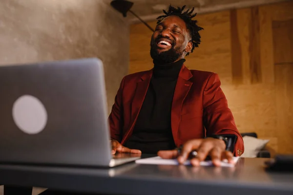 自信を持って若いアフリカ人男性はオフィスでウェブカメラ会議ビデオ通話を見て、幸せな混合レース起業家はオンラインビデオチャットジョブインタビューを行う話は机の上に座る — ストック写真
