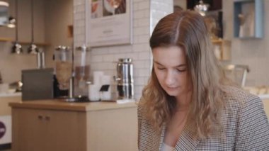 Genç iş kadını otel restoranında kahvaltı yapıyor.