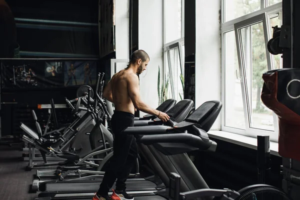 Ο άνθρωπος που τρέχει σε ένα γυμναστήριο σε μια έννοια διάδρομο για την άσκηση, τη φυσική κατάσταση και τον υγιεινό τρόπο ζωής — Φωτογραφία Αρχείου