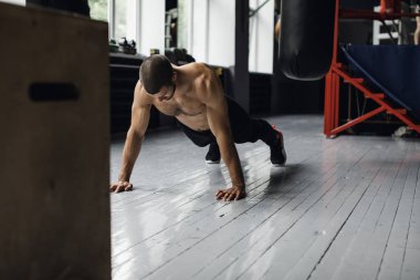 Egzersiz yaparken şınav çeken neşeli sporcu.