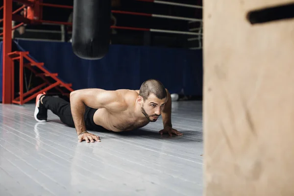 Радостный спортсмен делает упражнения с отжиманием во время тренировки — стоковое фото