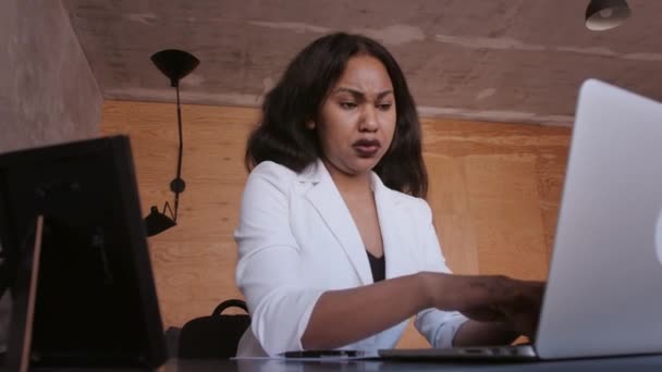 Die schwarze Geschäftsfrau setzt auf einen Taschenrechner und macht sich Notizen. Finanzier oder Buchhalter arbeitet von zu Hause aus — Stockvideo