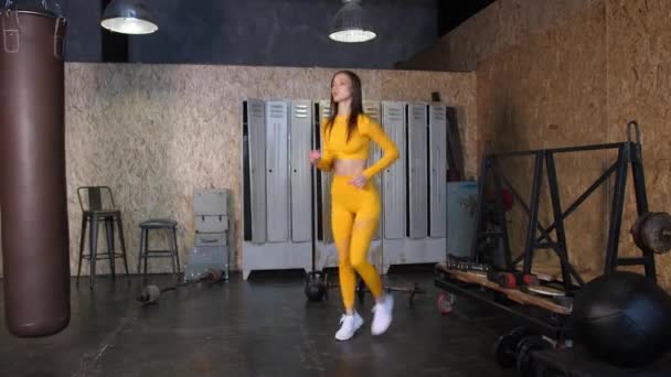 Dívka sportovec dělá warm-up před tréninkem v moderní tělocvičně — Stock video