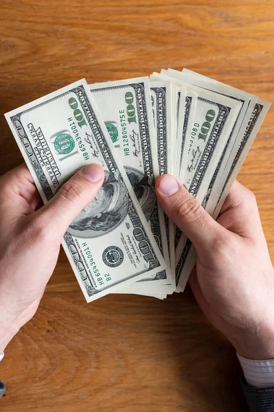 Manos masculinas contando billetes de US Dollar o pagando en efectivo sobre fondo de dinero. Concepto de inversión, éxito, perspectivas financieras — Foto de Stock