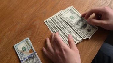 Takım elbiseli bir iş adamı. Eller bize dolar sayıyor.