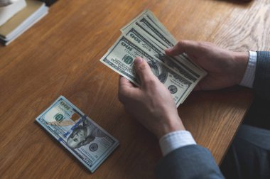 İş adamı dolar sayar. 100 dolarlık banknotlar. iş kavramı