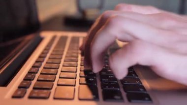 Dizüstü bilgisayar klavyesinde yazı yazan programcı ya da serbest çalışan erkek eller bilgisayar uygulamaları teknolojisi konseptiyle çalışan ofis masasında oturur, kenar görünümü kapatır