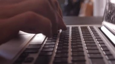 Dizüstü bilgisayar klavyesinde yazı yazan programcı ya da serbest çalışan erkek eller bilgisayar uygulamaları teknolojisi konseptiyle çalışan ofis masasında oturur, kenar görünümü kapatır