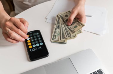 İş adamı para sayıyor, para biriktiriyor, ve gelecek için notlar alıyor ve aile için gelir giderlerini hesaplıyor, para tasarrufu fikirleri ve para sayıyor.