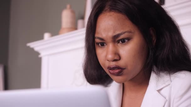 젊은 아프리카 계 미국인 사업가가 밝은 현대 사무실에서 책상에서 노트북으로 일하고 있는 모습 — 비디오