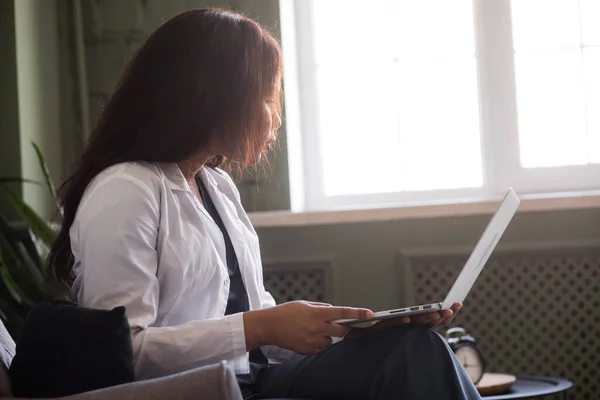 Female african doctor talking on conference video call. Virtual therapist consulting during online appointment on laptop at home. Telemedicine chat, telehealth meeting