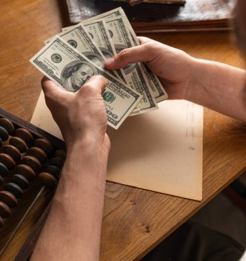 Erkek eller Amerikan dolarlarını sayıyor ya da para geçmişinde nakit ödüyor. Yatırım kavramı, başarı, finansal beklentiler