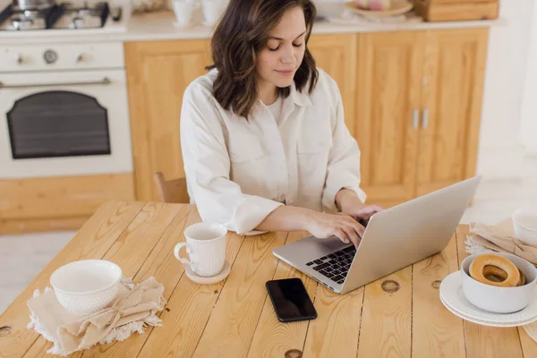 Portret van de jonge succesvolle blanke vrouwelijke freelancer zitten aan het bureau thuis. Zelfverzekerde vrouw werkt online op laptop thuis. — Stockfoto