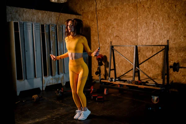 Una chica deportiva salta en una cuerda en un gimnasio moderno. fotos en movimiento — Foto de Stock