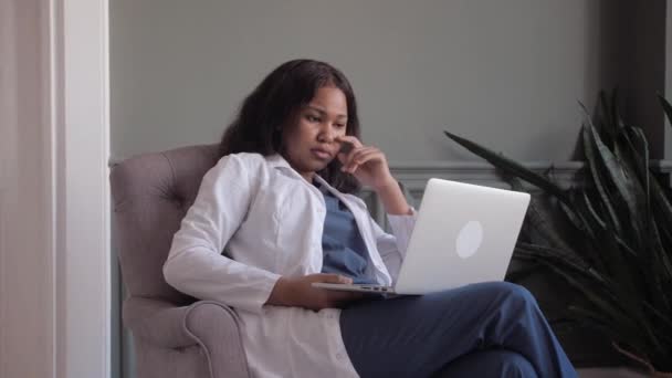 Mulher médica afro-americana realiza videoconferência com paciente. telemedicina. Conferência remota médico e paciente — Vídeo de Stock