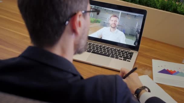 Por encima de la vista del hombro de los trabajadores masculinos tienen webcam conferencia virtual digital. Empresario hablar hablar en videollamada con el gerente. Concepto de reunión en línea. — Vídeos de Stock