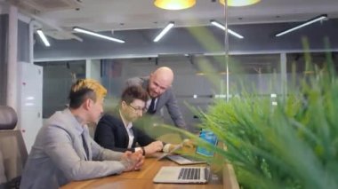 Proje Lideri ve ekibi dizüstü bilgisayarda gösterilen verileri tartıştı. Ekranlar Bilgiyi Gösterir, Mali Analiz, Borsa