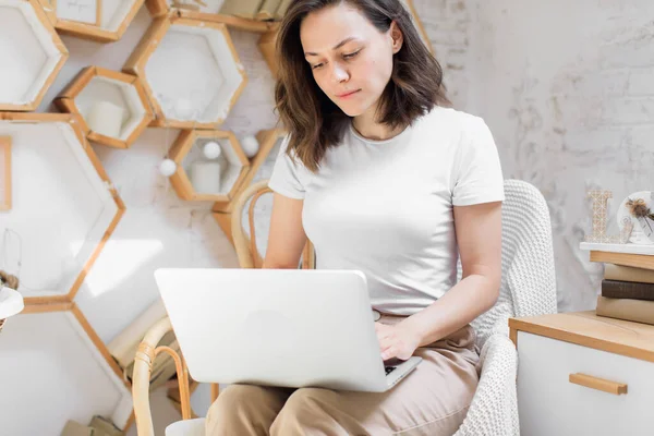 Jong aantrekkelijk meisje, maakt gebruik van een laptop in bed. Werk op afstand van huis — Stockfoto