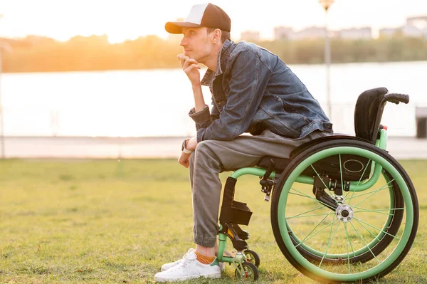 Инвалид в инвалидном кресле. Инвалид в инвалидном кресле для прогулок на закате — стоковое фото
