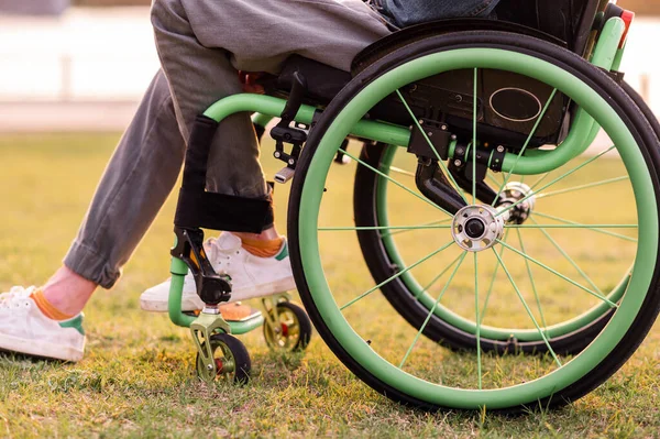 Инвалид сидит в инвалидном кресле. Он держит руки на руле.. — стоковое фото
