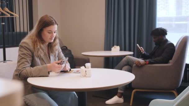 Um homem afro-americano e uma menina de aparência europeia, encontram-se em um restaurante. Uma conversa entre duas pessoas — Vídeo de Stock
