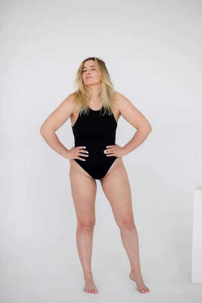 Hermosa mujer con sobrepeso en traje de baño negro sobre fondo blanco — Foto de Stock