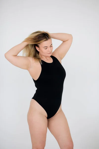 Hermosa mujer con sobrepeso en traje de baño negro sobre fondo gris —  Fotos de Stock