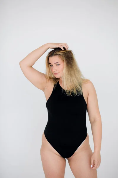 Cantik kelebihan berat badan wanita dalam pakaian renang hitam pada latar belakang abu-abu — Stok Foto
