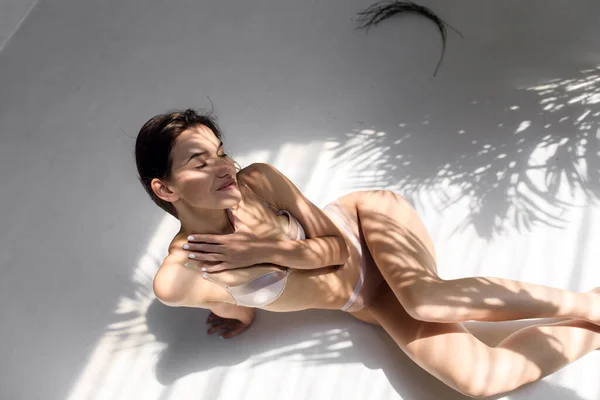 Ragazza con una bella figura in lingerie gode del sole. Giovane modello femminile godendo mattina di sole — Foto Stock