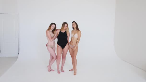 우정,아름다움, 긍정적 인 몸매 그리고 사람들의 개념 - 회색 바탕에 속옷을 입고 서로 다른 행복 한 여자들의 집단 — 비디오