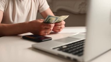 İş adamı para sayıyor, para biriktiriyor, ve gelecek için notlar alıyor ve aile için gelir giderlerini hesaplıyor, para tasarrufu fikirleri ve para sayıyor.