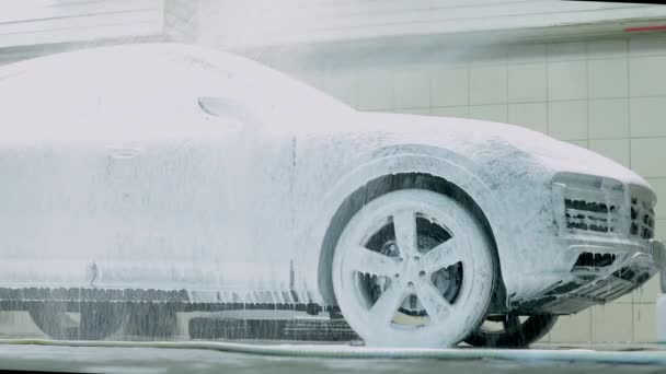 Carro de limpeza com shampoo de espuma de neve branca. Pulverizando espuma de neve branca no capô do carro e farol. Pulverizando espuma de xampu de carro para capuz de carro — Vídeo de Stock