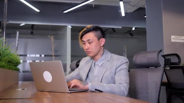 Portrait un jeune homme d'affaires asiatique sont intelligents et beau costume assis chaise tout en se sentant confiant avec sourire comme un sourire sur le visage en regardant la caméra avec ordinateur portable — Video