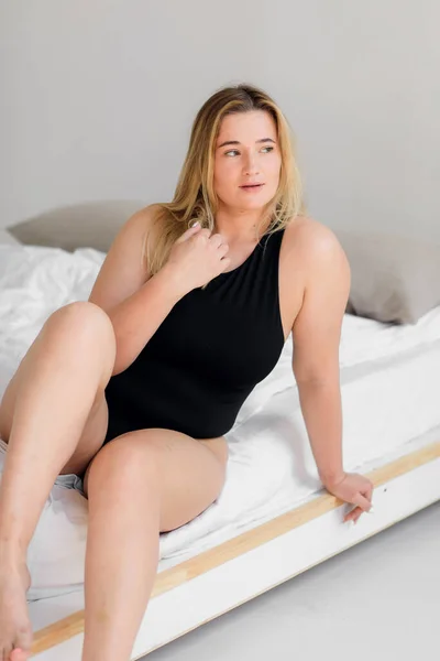 Schöne übergewichtige Frau im schwarzen Badeanzug auf weißem Hintergrund — Stockfoto